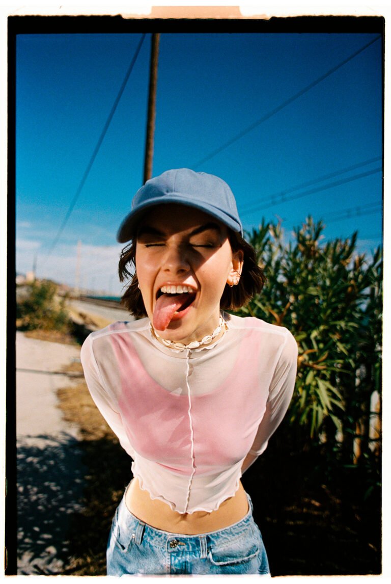 A portrait of a young model showing her tongue. Young fashion photography.