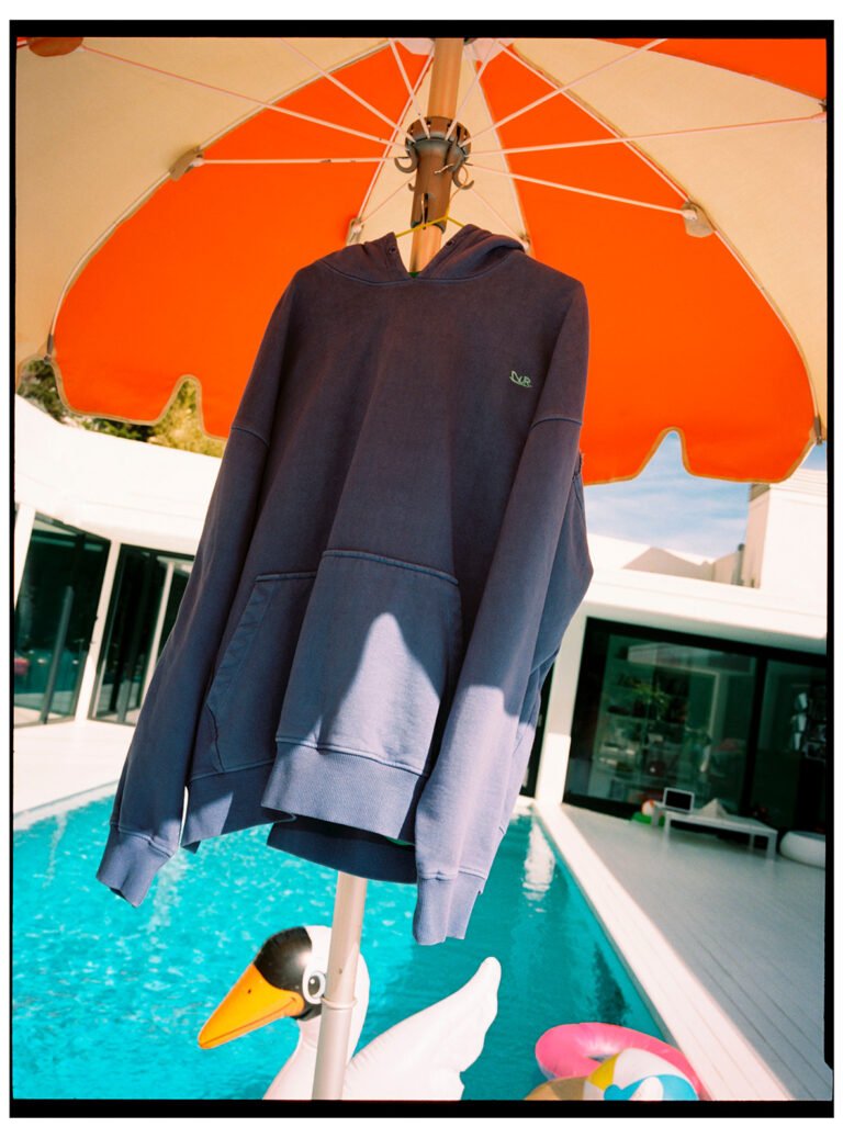 Fashion shoot with a blue hoodie next to the pool