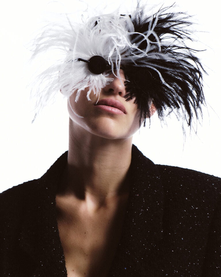 Portrait of a model with her eyes covered with black and white feathers