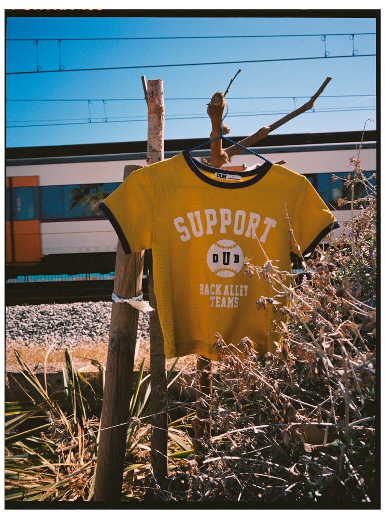 Yellow sports t-shirt is hanging next to a rail road. Urban fashion photography.