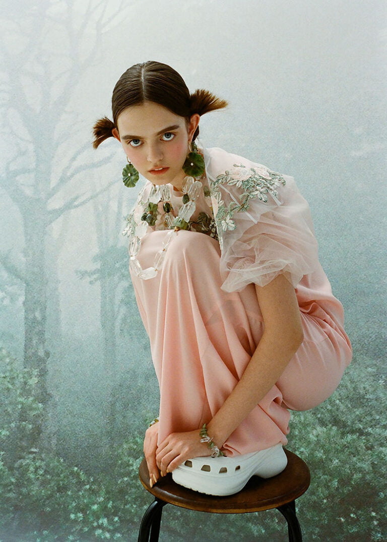 Model in a pink dress wearing green earrings. Fashion and jewellery photography.