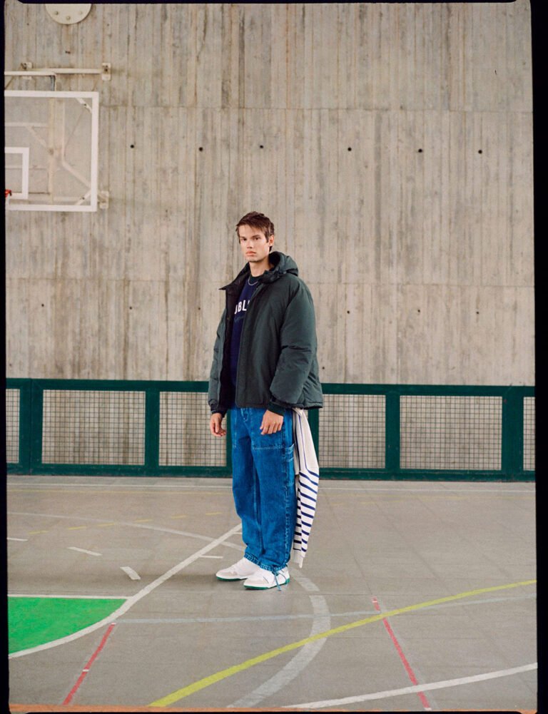 A young man wearing parka in a gym