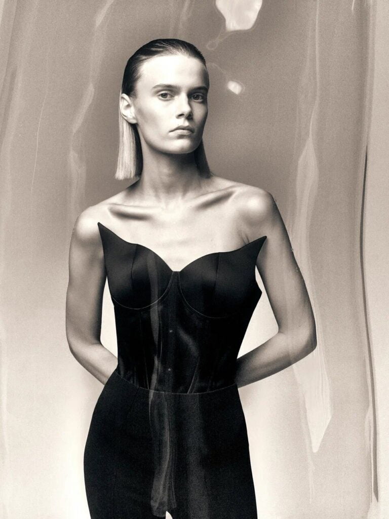 Monochrome photograph of a model in black