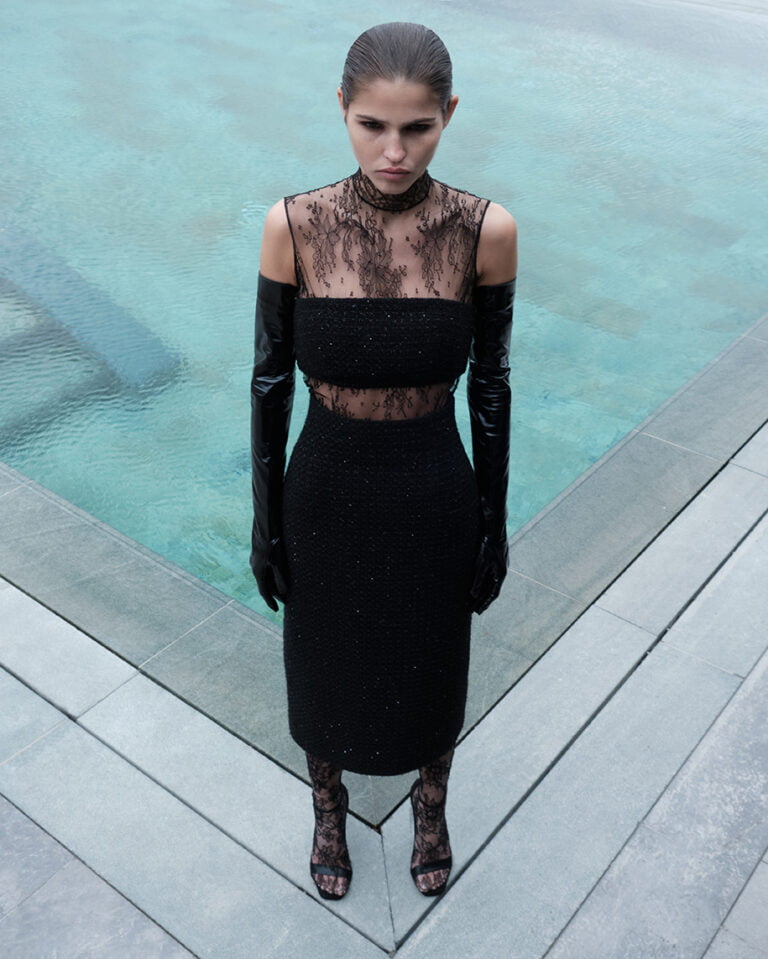 Portrait of a model in black outfit next to the swimming pool