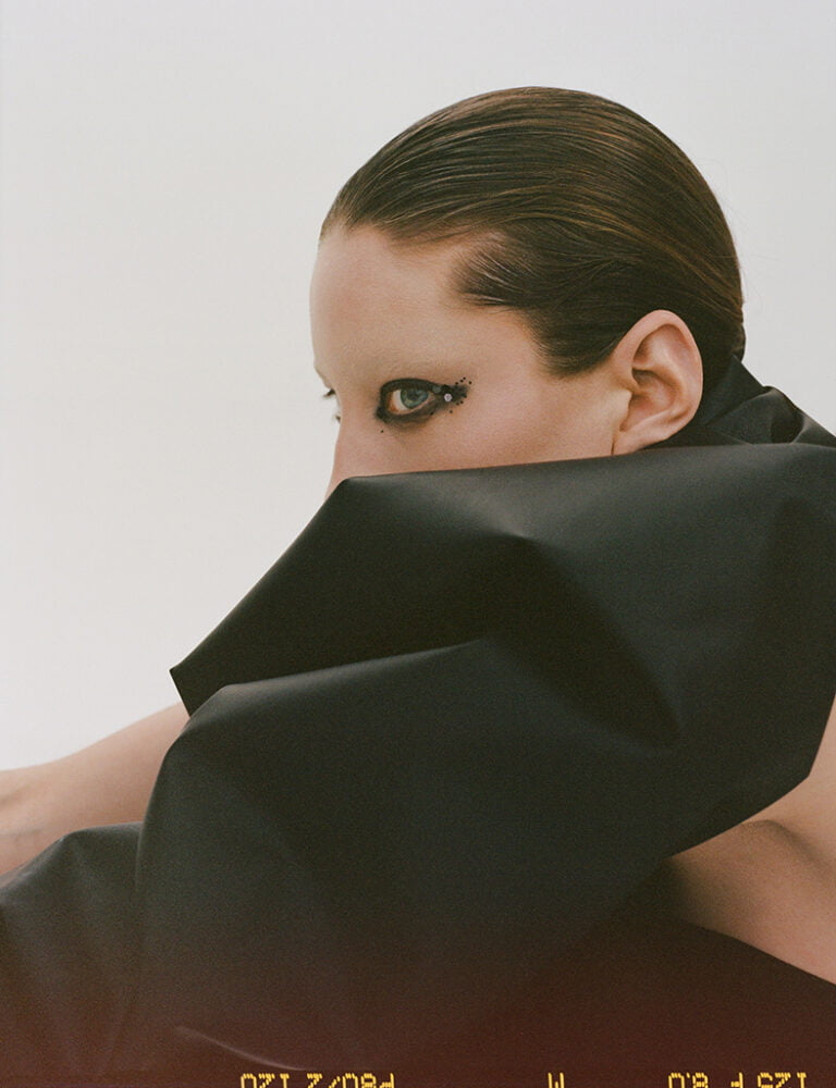 Portrait of a model hiding a half of her face under black fabric