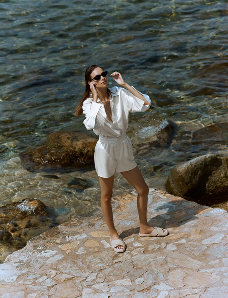 Fashion model in white outfit at the sea