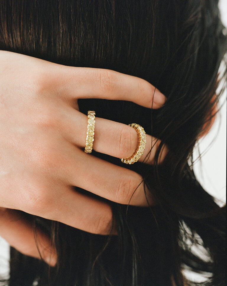 Hand in hair with gold rings. Jewellery photography.