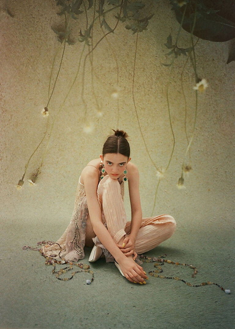 Photograph of jewellery on a youg model sitting on the floor. TATYANA PARFIONOVA x NADJIA AZENET JEWELLERY