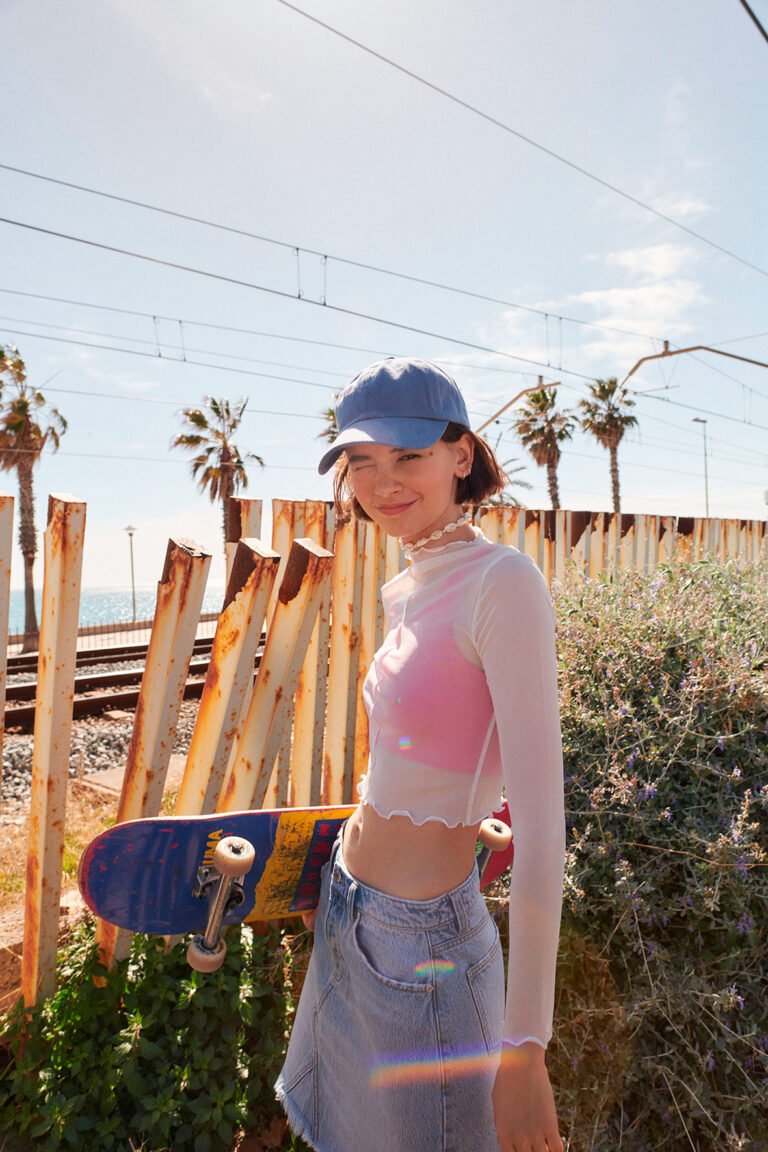 Photograph of a young model with a skateboard. Urban fashion.